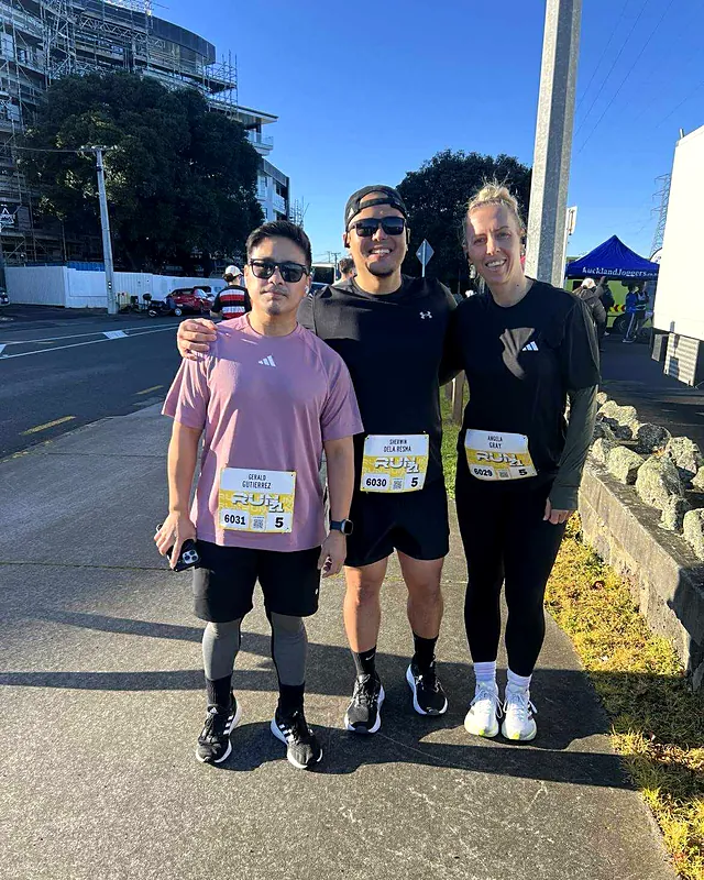 Sherwin with friends after finishing his first 5K run, wearing race bibs